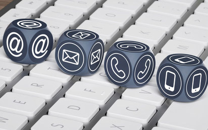 cztery granatowe kostki do rzucania z ikonami wiadomości e-mail, koperty,  telefonu i smartfona na białej klawiaturze